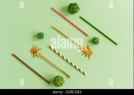 Flaches Layout von bunten festlichen Cocktailröhren auf grünem Hintergrund. Das Konzept von Party und Urlaub Stockfoto