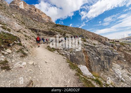 Wanderer auf dem Weg vor der Südwand der drei Gipfel des Lavaredo (drei Zinnen oder Tre Cime di Lavaredo), Sextner Dolomiten, Italien. Stockfoto