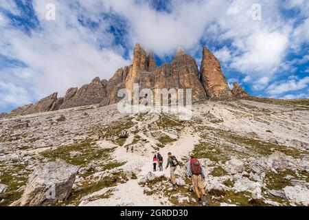 Wanderer auf dem Weg vor der Südwand der drei Gipfel des Lavaredo (drei Zinnen oder Tre Cime di Lavaredo), Sextner Dolomiten, Italien. Stockfoto