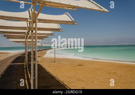 Ausgestatteter Strand am Toten Meer mit Salz sichtbar am Ufer Stockfoto