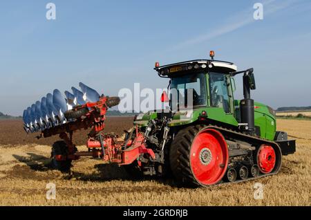 Traktor mit Pflug im Herbstfeld Stockfoto