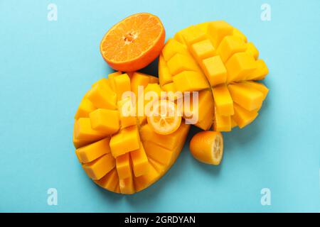 Reife Mango und Orange auf blauem Hintergrund. Stockfoto