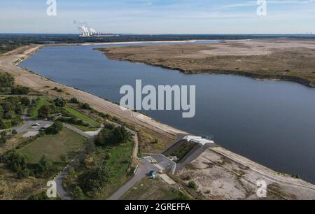 01. Oktober 2021, Brandenburg, Cottbus: Die ehemalige Braunkohlebergwerk Cottbus-Nord füllt sich langsam mit Wasser und wird so zur Cottbuser Ostsee (Luftaufnahme mit Drohne). Die Landmasse rechts auf dem Foto wird in den nächsten Jahren ebenfalls im Wasser verschwinden. Mitte April 2019 begann die Überschwemmung der ehemaligen Tagebaumine Cottbus-Nord. Das Energieunternehmen Lausitz Energie Bergbau AG (LEAG) lässt für das Hochwasser Wasser aus der Spree über den Hammergraben in das Tagebauloch fließen - rund 45 Millionen Kubikmeter pro Jahr sind geplant. Der riesige künstliche See ist Stockfoto