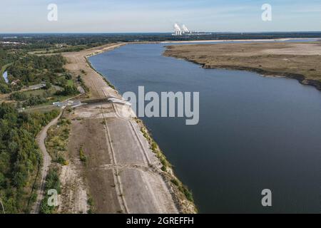 01. Oktober 2021, Brandenburg, Cottbus: Die ehemalige Braunkohlebergwerk Cottbus-Nord füllt sich langsam mit Wasser und wird so zur Cottbuser Ostsee (Luftaufnahme mit Drohne). Die Landmasse rechts auf dem Foto wird in den nächsten Jahren ebenfalls im Wasser verschwinden. Mitte April 2019 begann die Überschwemmung der ehemaligen Tagebaumine Cottbus-Nord. Das Energieunternehmen Lausitz Energie Bergbau AG (LEAG) lässt für das Hochwasser Wasser aus der Spree über den Hammergraben in das Tagebauloch fließen - rund 45 Millionen Kubikmeter pro Jahr sind geplant. Der riesige künstliche See ist Stockfoto