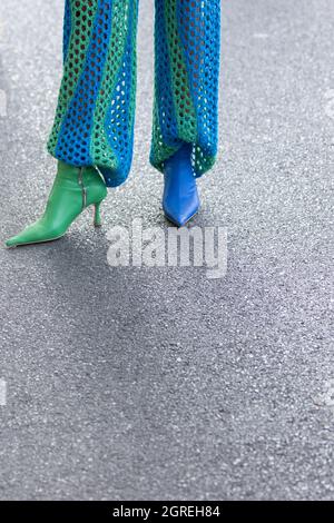 24. September 2021: Das Model trägt ein Paar blaue und grüne Lederstiefel Stockfoto