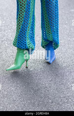 24. September 2021: Das Model trägt ein Paar blaue und grüne Lederstiefel Stockfoto