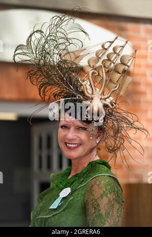 Lady trägt einen Designerhut mit einem alten Segelschiff auf der Oberseite, bevor sie Royal Ascot besucht Stockfoto