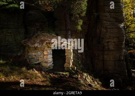 Kleine Steinhütte mitten im Wald, sonniger Herbsttag Stockfoto
