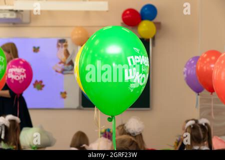 Schüler und Lehrer in einer Schulklasse in einer Lektion am 1. September mit bunten Ballons. Die Inschrift ist Hello School. Sele Stockfoto