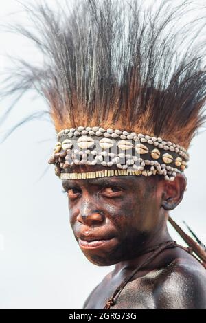 Indonesien, Papua, Stadt Wamena, Porträt eines jungen Dani-Jungen. Baliem Valley Cultural Festival, jedes Jahr im August kommen Stämme zusammen, um uralte Kriegsszenen aufzuführen, Parade und Tanz in traditioneller Kleidung Stockfoto