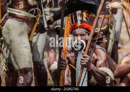 Indonesien, Papua, Stadt Wamena, bewaffnete Angehörige des Dani-Stammes, die eine Stammeskriegsszene nachspielen. Baliem Valley Cultural Festival, jedes Jahr im August kommen Stämme zusammen, um uralte Kriegsszenen aufzuführen, Parade und Tanz in traditioneller Kleidung Stockfoto