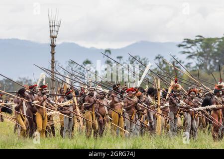 Indonesien, Papua, Stadt Wamena, bewaffnete Angehörige des Dani-Stammes, die eine Stammeskriegsszene nachspielen. Baliem Valley Cultural Festival, jedes Jahr im August kommen Stämme zusammen, um uralte Kriegsszenen aufzuführen, Parade und Tanz in traditioneller Kleidung Stockfoto