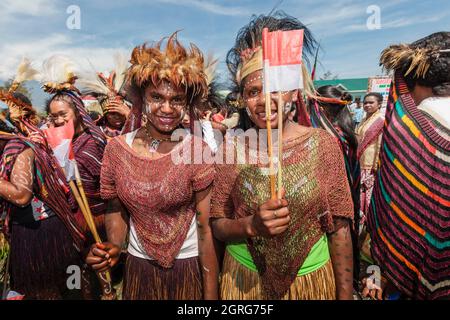 Indonesien, Papua, das Stadtzentrum von Wamena, junge Frauen aus dem Dani-Stamm, Feier des Unabhängigkeitstages Indonesiens. Jeder Stamm ist eingeladen, mit der indonesischen Flagge zu marschieren und seine Kultur durch traditionelle Tänze und Kleidung zu zeigen, um das Gefühl kultureller Freiheit zu stärken. Stockfoto