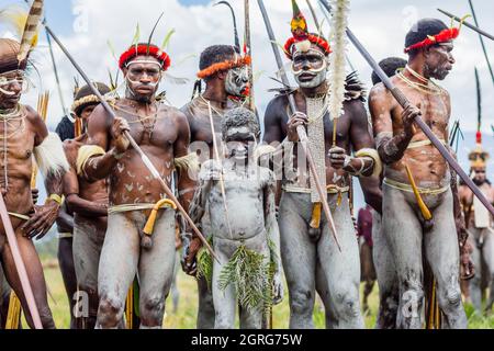 Indonesien, Papua, Stadt Wamena, bewaffnete Angehörige des Dani-Stammes, die eine Stammeskriegsszene nachspielen. Baliem Valley Cultural Festival, jedes Jahr im August kommen Stämme zusammen, um uralte Kriegsszenen aufzuführen, Parade und Tanz in traditioneller Kleidung Stockfoto