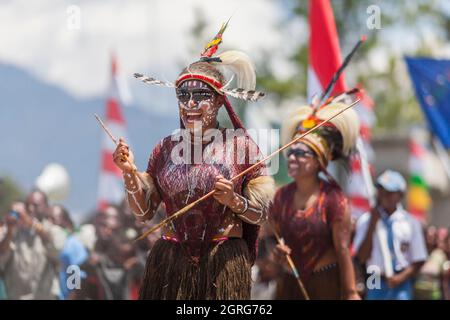 Indonesien, Papua, das Stadtzentrum von Wamena, junge Frauen aus dem Dani-Stamm, Feier des Unabhängigkeitstages Indonesiens. Jeder Stamm ist eingeladen, mit der indonesischen Flagge zu marschieren und seine Kultur durch traditionelle Tänze und Kleidung zu zeigen, um das Gefühl kultureller Freiheit zu stärken. Stockfoto