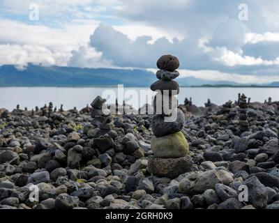 Steine in cairns an einem Ufer in Reykjavik, Island. Stockfoto