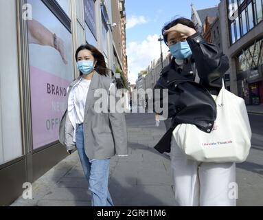 London, England, Großbritannien. Asiatische junge Frauen mit Gesichtsmasken in Covent Garden, September 2021 Stockfoto