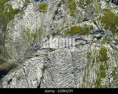 VERTIKALE LUFTAUFNAHME. Interessantes Muster von Rillen auf der Oberfläche eines erodierten Kalksteinplateaus. Desert de Platé, Sixt-Fer-à-Cheval, Frankreich. Stockfoto