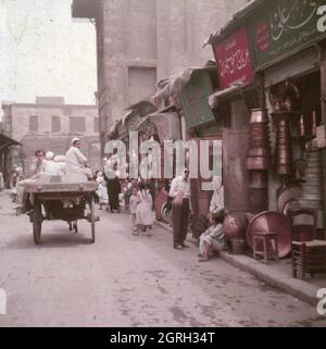 Straßenszene in einer Gasse vor Geschäften in der Altstadt von Kairo, Ägypten 1955. Straßenszene vor Geschäften an einer kleinen Gasse in der Altstadt von Kairo, Ägypten 1955. Stockfoto