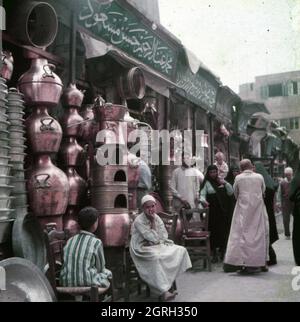 Straßenszene in einer Gasse vor Geschäften in der Altstadt von Kairo, Ägypten 1955. Straßenszene vor Geschäften an einer kleinen Gasse in der Altstadt von Kairo, Ägypten 1955. Stockfoto