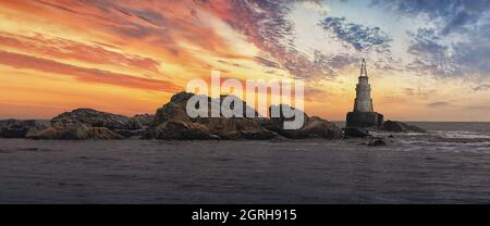 Sonnenaufgang über den Felsen und dem verlassenen Leuchtturm. Nebliger Sonnenaufgang des Leuchtturms in Ahtopol, Bulgarien. Blaue Meereslandschaft. Langzeitbelichtung. Panorama Stockfoto