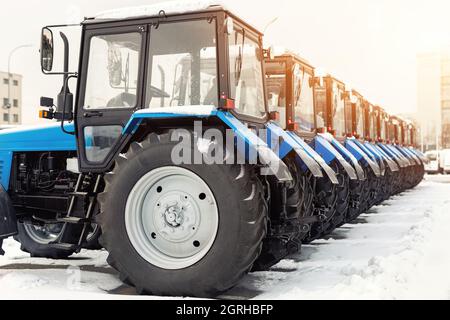 Viele verschiedene Traktoren stehen in Reihe auf der Landwirtschaftsmesse zum Verkauf im Freien.Ausrüstung für die Landwirtschaft.Schwere industrielle Maschinen vorgestellt Stockfoto