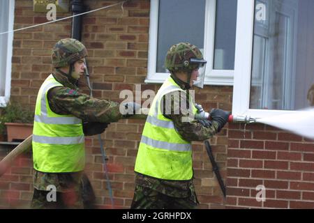 24-11-02 Green Goddeess Army Fire Engine Army Feuerwehrleute am Schauplatz eines Schussfeuers auf der Grindsbrook Road, Radcliffe, Manchester während des 2002 Feuerwehrstreiks. Eine Grüne Göttin kam 15 Minuten nach Beginn des Feuers nach Angaben eines Anwohners an. Der Schuppen, der eine Drehbank zu enthalten schien, wurde völlig zerstört und die Rückseite des Hauses weitgehend beschädigt. Ein atmendes Aparatus-Team wurde ebenfalls in das Haus geschickt. Stockfoto