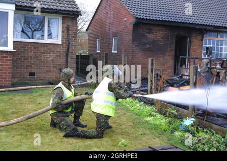 24-11-02 Green Goddeess Army Fire Engine Army Feuerwehrleute am Schauplatz eines Schussfeuers auf der Grindsbrook Road, Radcliffe, Manchester während des 2002 Feuerwehrstreiks. Eine Grüne Göttin kam 15 Minuten nach Beginn des Feuers nach Angaben eines Anwohners an. Der Schuppen, der eine Drehbank zu enthalten schien, wurde völlig zerstört und die Rückseite des Hauses weitgehend beschädigt. Ein atmendes Aparatus-Team wurde ebenfalls in das Haus geschickt. Stockfoto