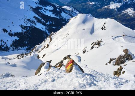 Off-Piste-Skigebiet in Arosa Lenzerheide, Schweiz, mit einem touristischen Marker auf einem Felsen. Landschaft, Bergrücken, Winter. Stockfoto