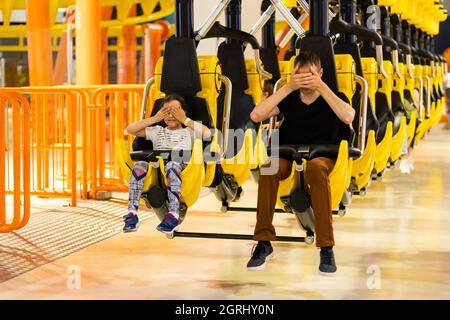 Lächelnd Familie reiten auf einer Achterbahnfahrt in einem Vergnügungspark. Stockfoto