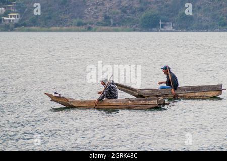 SANTIAGO ATITLAN, GUATEMALA - 23. MÄRZ 2016: Fischer auf traditionellen Holzbooten auf dem Atitlan See in der Nähe des Dorfes Santiago Atitlan. Stockfoto