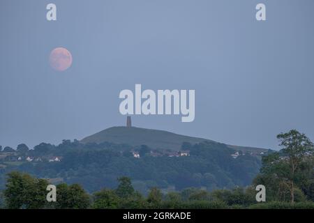 Glastonbury Tor von den Mooren bei Sonnenuntergang. Mit einem aufgehenden Vollmond. Stockfoto