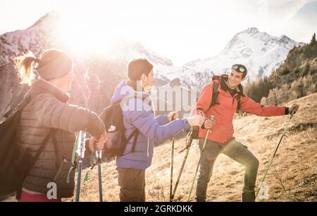 Gruppe von Freunden Trekking auf den französischen alpen bei Sonnenuntergang - Wanderer mit Rucksäcken und Stöcken Wandern auf den Bergen - Wanderlust Reisekonzept Stockfoto