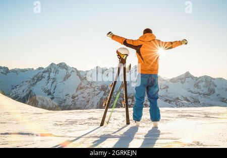 Junger Profi-Skifahrer bei Sonnenuntergang im Relax-Moment im skigebiet der französischen alpen - Wintersport-Konzept mit Abenteuermann auf der Bergspitze bereit zu reiten Stockfoto