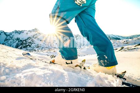 Die Beine des professionellen Skifahrers bei Sonnenuntergang im Relax Moment im skigebiet der französischen alpen - Wintersport-Konzept mit Abenteuermann auf der Bergspitze bereit zu reiten Stockfoto