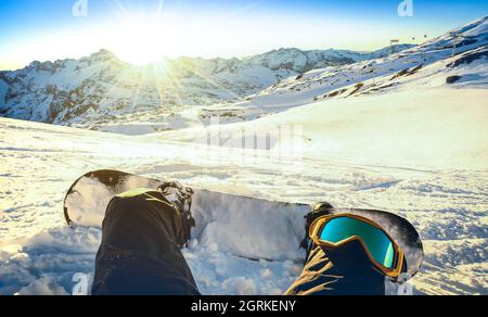 Snowboarder im Skigebiet Les Deux Alpes im Moment der Entspannung bei Sonnenuntergang - Wintersport-Konzept mit Person auf dem Berg bereit zu reiten Stockfoto