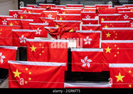 Hongkong, China. Oktober 2021. Eine zusammengefaltete chinesische Flagge in einem Markt während des Nationaltages zwischen Reihen chinesischer und Hongkonger Flaggen.Reihen chinesischer und Hongkonger Flaggen wurden in der ganzen Stadt zum 72. Nationaltag der Volksrepublik China in Hongkong aufgestellt. Kredit: SOPA Images Limited/Alamy Live Nachrichten Stockfoto