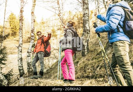 Freunde Gruppe Trekking im Wald auf den französischen alpen bei Sonnenuntergang - Wanderer mit Rucksäcken und Stöcken Wandern auf Bergwäldern - Wanderlust Reisekonzept Stockfoto