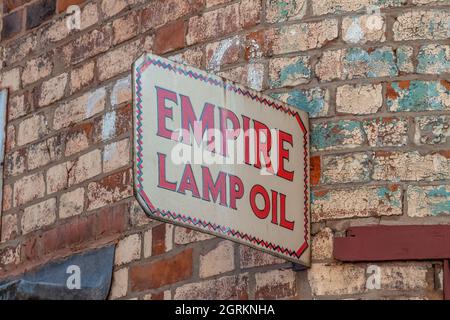 Empire Lamp Öl Emaille Zeichen auf verblassenden Ziegelwand Stockfoto