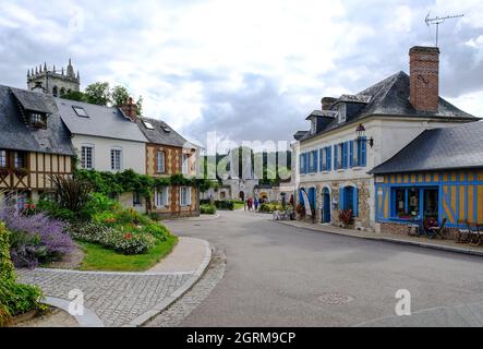 Frankreich, Le Bec-Hellouin, 28.08.2021: Zentraler Platz mit typischen Fachwerkhäusern und Blick auf die Abtei Le Bec, Turm Saint-Nicolas und Eingang Stockfoto