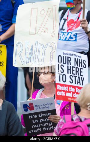 Die Teilnehmer versammeln sich und marschieren während eines Protestes, in dem die Regierung aufgefordert wird, medizinische Fachkräfte fair zu bezahlen und den NHS in London zu retten. Stockfoto