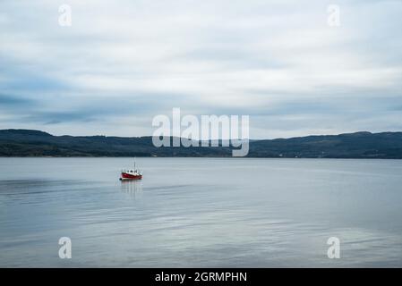 Das einsame Boot, allein in einer riesigen Wasserfläche. Stockfoto