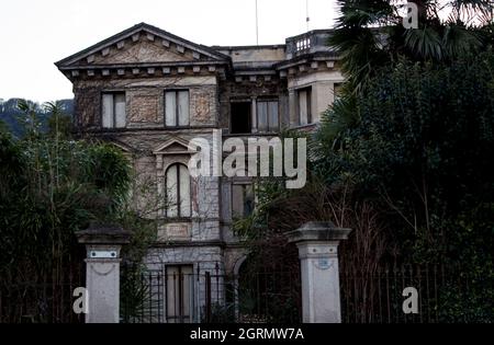 Alte zerstörte Villa, in der Vegetation alle in den dunklen Tönen typisch für Halloween eingetaucht, Foto bewusst unterbelichtet, um einen dunkleren gruseligen Effekt zu geben Stockfoto