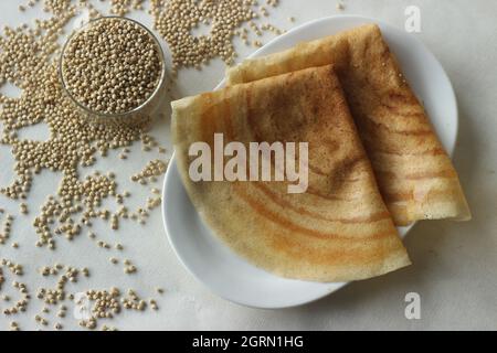 Sorghum Pfannkuchen. Knusprige Pfannkuchen aus Vollkorn-Sorghum und Leinenschalen. Im Volksmund als Jowar dosa bekannt. Aufgenommen auf weißem Hintergrund Stockfoto