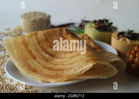 Sorghum Pfannkuchen. Knusprige Pfannkuchen aus Vollkorn-Sorghum und Leinenschalen. Im Volksmund als Jowar dosa bekannt. Serviert mit Kichererbsen-Masala und Gewürzen. Stockfoto