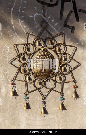 Ein indisches religiöses Symbol des Buddha aus Messing hing aus nächster Nähe an einer Wand Stockfoto