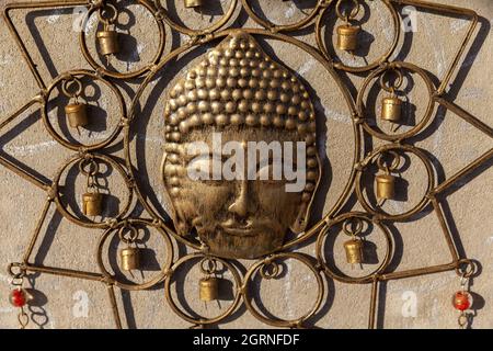 Ein indisches religiöses Symbol des Buddha aus Messing hing aus nächster Nähe an einer Wand Stockfoto