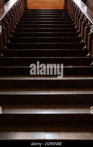 Lange alte dunkle Treppe aus einem Naturstein Stockfoto