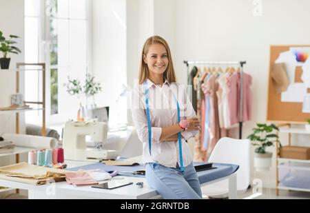 Porträt einer Schneiderin, Modedesignerin, Schneiderin oder Näherin bei der Arbeit in ihrem eigenen Atelier. Stockfoto