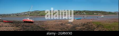 Panoramablick mit einer kleinen roten Yacht und anderen Booten, die auf niedrigem Wasser in der Flussmündung Teign in der Nähe von Teignmouth South Devon England auf Grund gehen Stockfoto